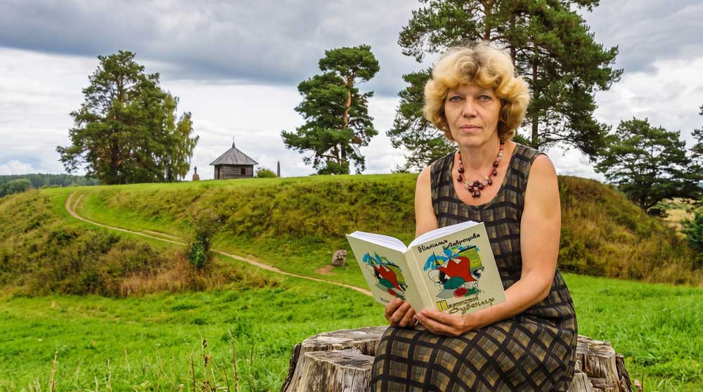 Наталья Анатольевна Лаврецова с авторским изданием своей книги «Парижский сувенир» у подножия городища Савкина Горка. Цифровая художественная реконструкция выполнена на основе прижизненного архивного фотопортрета из фондов Государственного мемориального историко-литературного и природно-ландшафтного музея-заповедника А. С. Пушкина «Михайловское». Образ воссоздан в стилистике классической пейзажно-интерьерной фотографии начала XXI века на фоне заповедного пушкиногорского ландшафта с детальным воспроизведением оригинального библиографического оформления книги автора и графических элементов обложки. Компьютерная обработка, дизайн, проработка элементов обложки и пространственная композиция — А. В. Камянчук.
